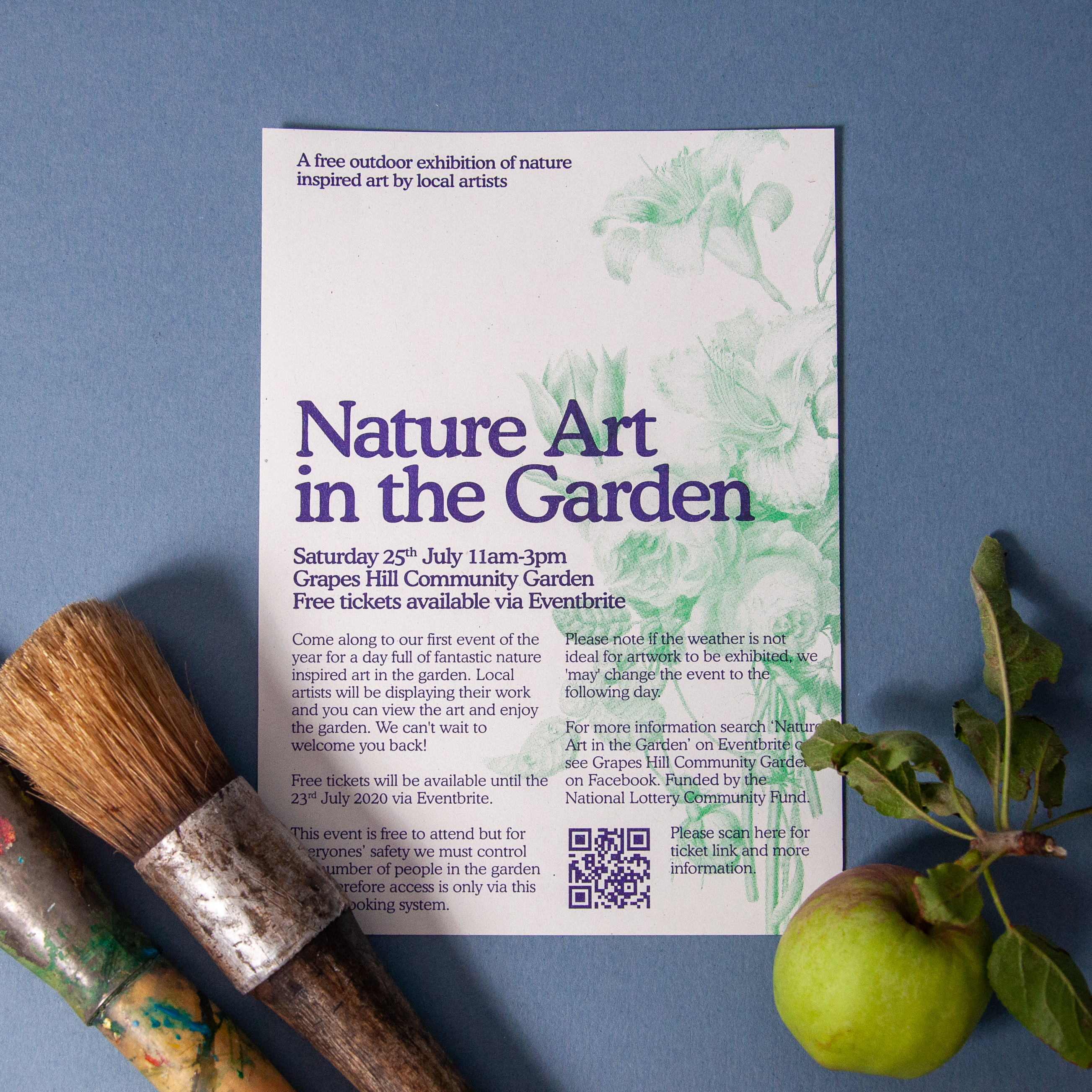 A photograph of a flyer for 'Nature in the Garden', surrounded by an apple and a mug full of paintbrushes.